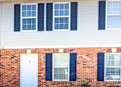 Thumbnail 2 of 35 - A red brick house with white doors and windows.