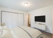 Thumbnail 26 of 43 - a bedroom with a bed and a television on the wall
