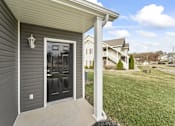 Thumbnail 29 of 67 - the front door of a home with a lawn and houses in the background