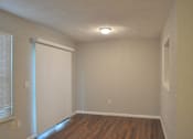 Thumbnail 47 of 51 - A room with a white door and wooden floor.