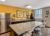 Thumbnail 13 of 42 - a kitchen with a granite counter top and a stainless steel refrigerator
