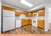 Thumbnail 17 of 35 - A kitchen with wooden cabinets and a white refrigerator.