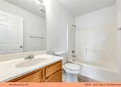 Thumbnail 30 of 35 - A white bathroom with a sink, toilet and bathtub.
