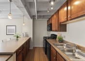 Thumbnail 7 of 43 - a kitchen with wood cabinets and a counter top and a sink