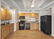 Thumbnail 21 of 43 - a kitchen with black appliances and wooden cabinets