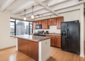 Thumbnail 38 of 43 - a kitchen with a large island and a black refrigerator