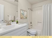 Thumbnail 23 of 24 - A white bathroom with a toilet, sink, and shower.