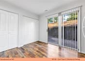 Thumbnail 19 of 35 - A kitchen and dining area with white doors and a wooden floor.
