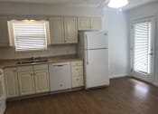 Thumbnail 19 of 51 - A kitchen with white appliances and wooden floors.