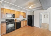 Thumbnail 24 of 43 - a kitchen with black appliances and wood flooring and a black refrigerator