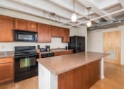 Thumbnail 40 of 43 - a kitchen with a granite counter top and black appliances
