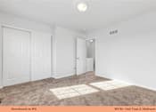 Thumbnail 22 of 35 - A bedroom with a carpeted floor and white walls.