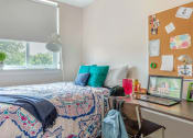 Thumbnail 36 of 42 - a bedroom with a bed and a desk with a laptop