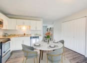 Thumbnail 2 of 43 - a dining area with a table and chairs and a kitchen in the background