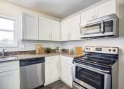 Thumbnail 12 of 43 - a kitchen with white cabinets and stainless steel appliances