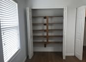 Thumbnail 29 of 51 - A white closet with a wooden shelf and a window with blinds.