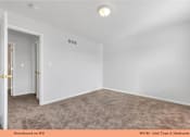 Thumbnail 29 of 35 - A room with a carpeted floor and a door on the left.