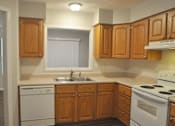 Thumbnail 35 of 51 - A kitchen with wooden cabinets and white appliances.