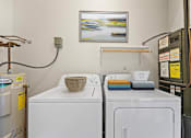 Thumbnail 37 of 67 - a laundry room with two washing machines and a painting on the wall