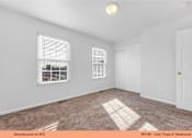 Thumbnail 28 of 35 - A white bedroom with a window and a door.