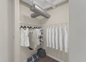 Thumbnail 12 of 43 - a closet with clothes hanging on a rack and a ceiling fan