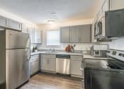 Thumbnail 22 of 43 - a kitchen with a refrigerator freezer and a stove top oven