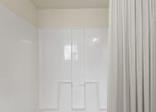 Thumbnail 25 of 43 - a bathroom with white walls and a shower curtain