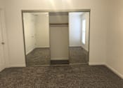 Thumbnail 21 of 51 - A large mirror in a room with carpeted floor.