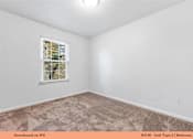 Thumbnail 23 of 35 - A bedroom with a carpeted floor and a window with blinds.