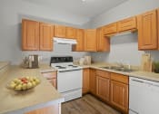 Thumbnail 40 of 48 - a kitchen with wooden cabinets and a bowl of fruit on the counter