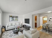 Thumbnail 14 of 48 - a living room with white couches and chairs and a tv on the wall
