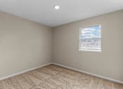Thumbnail 5 of 14 - A room with a carpeted floor and a window with blinds.