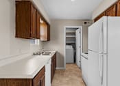 Thumbnail 10 of 14 - A kitchen with white appliances and brown cabinets.