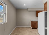 Thumbnail 9 of 14 - A kitchen area with a white refrigerator and wooden cabinets.