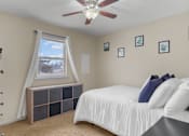 Thumbnail 13 of 14 - A bedroom with a bed, a window with curtains, and a ceiling fan.