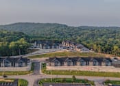 Thumbnail 3 of 38 - A large building complex surrounded by a forest.