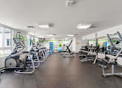 Thumbnail 18 of 56 - A gym with a variety of exercise equipment including treadmills, stationary bikes, and weight machines.