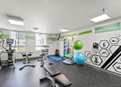 Thumbnail 22 of 56 - A gym with a variety of equipment including a treadmill, exercise bike, and weights.