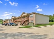 Thumbnail 1 of 30 - a row of apartment buildings with cars parked outside