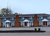 Thumbnail 1 of 64 - A row of houses with grey and brown exteriors.