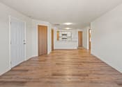 Thumbnail 39 of 64 - A long hallway with wooden floors and white walls.