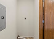 Thumbnail 29 of 64 - A room with a wooden door and a metal vent on the wall.