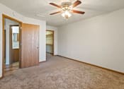 Thumbnail 12 of 64 - A room with a ceiling fan and carpeted floor.