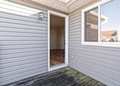 Thumbnail 20 of 64 - A grey house with a white door and window.