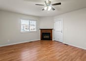 Thumbnail 15 of 64 - A room with a fireplace and a ceiling fan.