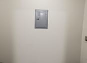 Thumbnail 63 of 64 - A grey electrical box mounted on a white wall.
