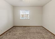 Thumbnail 57 of 64 - A room with a carpeted floor and a window showing a view of a house.