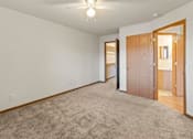 Thumbnail 55 of 64 - A room with a carpeted floor and a ceiling fan.