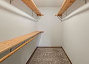 Thumbnail 56 of 64 - A long, narrow room with a carpeted floor and two wooden shelves.