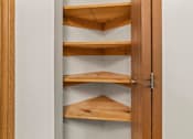 Thumbnail 53 of 64 - A wooden shelving unit with four shelves is open.